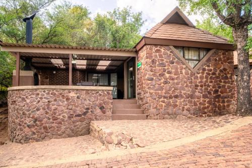 a stone house with a stone wall at ATKV Klein-Kariba in Bela-Bela