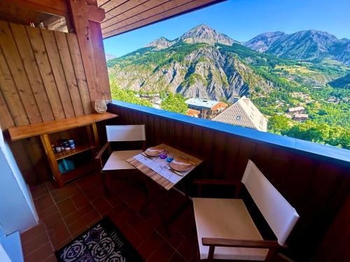 a room with a table and a view of mountains at Duplex avec vue exceptionnelle parking et wifi gratuit in Allos