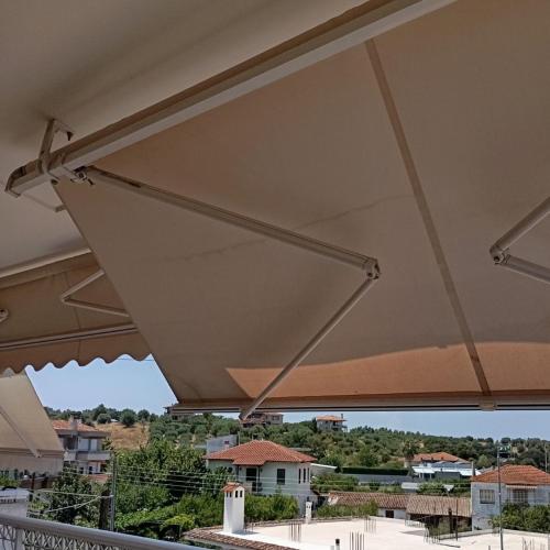 a patio umbrella with a view of a city at Chéz Vasŏ ** leisure maisonette** in Kassandria