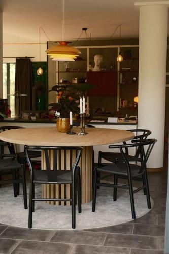 a table and chairs in a room with a kitchen at Pinecone Hideaway - huis in het bos in Aalter