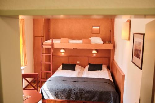 a small bedroom with two bunk beds in it at JUFA Hotel Meersburg am Bodensee in Meersburg