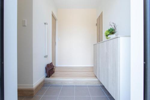 a hallway with white walls and a tile floor at Mova Villa Haramizu in Kikuchi