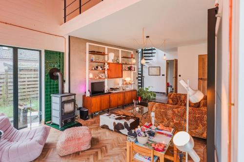 a living room with a couch and a fireplace at Pinecone Hideaway - huis in het bos in Aalter