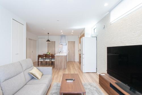 a living room with a couch and a flat screen tv at Mova Villa Haramizu in Kikuchi