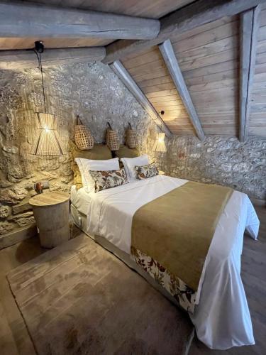 a bedroom with a large bed in a stone wall at Selene Luxury Rooms in Sinevrón
