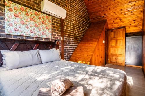 a bedroom with a bed and a brick wall at ATKV Klein-Kariba in Bela-Bela