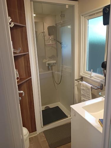 une salle de bain avec une douche avec une porte vitrée dans l'établissement Le HAVRE DU MEN DU, à Carnac