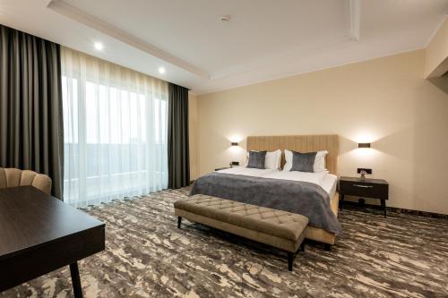 a large hotel room with a bed and a couch at Empire Balneo & Spa Hotel in Hisarya