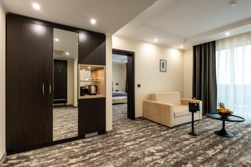 a living room with a couch and a chair and a mirror at Empire Balneo & Spa Hotel in Hisarya