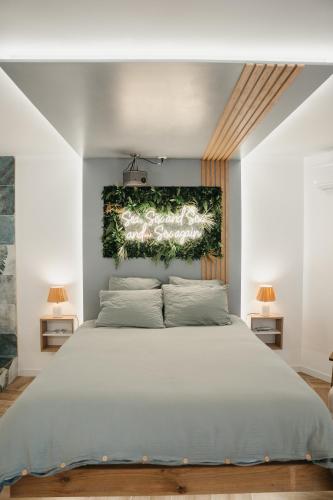 une chambre avec un grand lit avec un tableau au mur dans l'établissement Love & Sunsets Suite, à Sausset-les-Pins