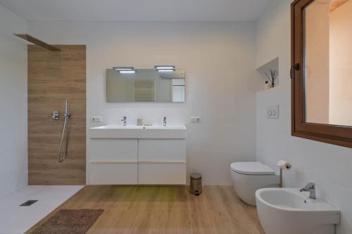 een badkamer met een wastafel, een toilet en een spiegel bij Luxury Villa Kerenza in Benissa