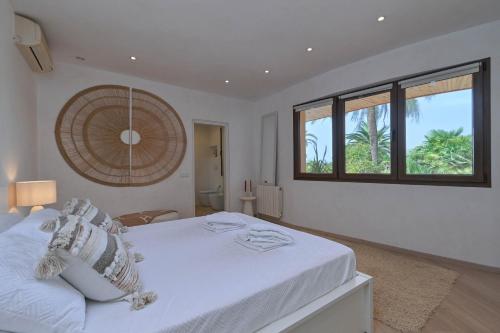 een slaapkamer met een wit bed met een raam bij Luxury Villa Kerenza in Benissa
