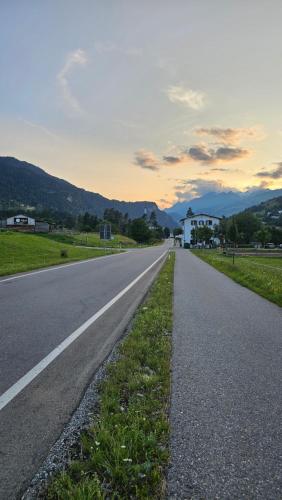 an empty road with a house in the distance at Landgasthof zum Glenner in Ilanz