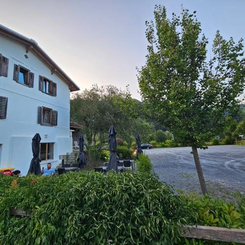 a building with a tree next to a building at Landgasthof zum Glenner in Ilanz