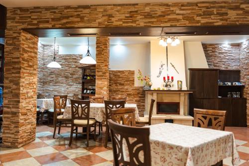 a dining room with a table and chairs and a fireplace at Hotel Villa Ofir in Sandanski