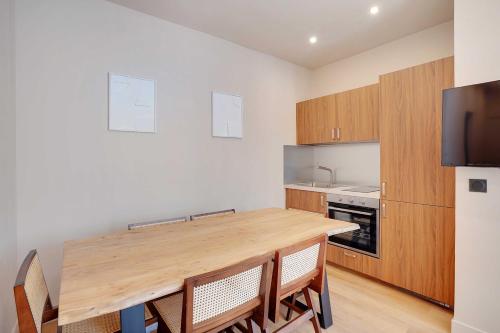 une cuisine avec une table en bois et quelques chaises dans l'établissement Refurbished Apartment - 2BD-8P - Place D'Italie, à Paris