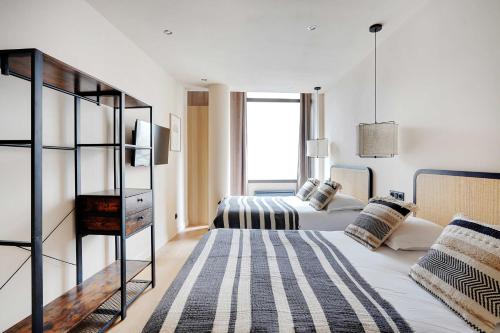 une chambre avec deux lits et une fenêtre dans l'établissement Refurbished Apartment - 2BD-8P - Place D'Italie, à Paris