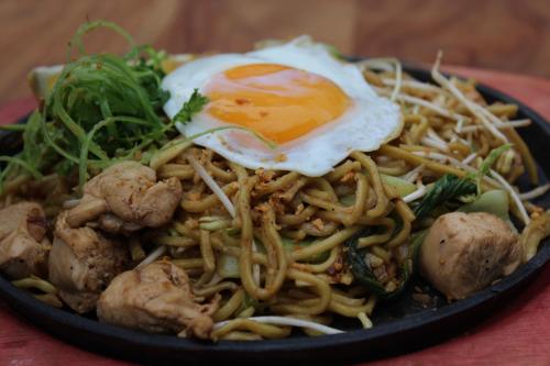 a plate of food with an egg on top of noodles at Best Western Plus The Ivywall Hotel - Palawan in Puerto Princesa City