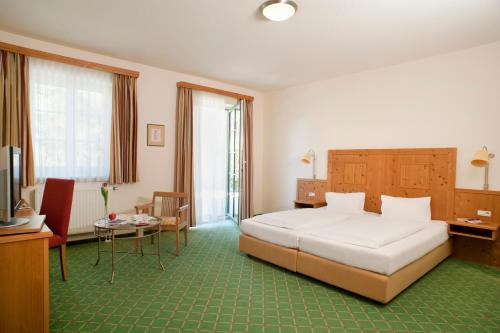 a bedroom with a bed and a desk and a television at Hotel Althof Retz in Retz