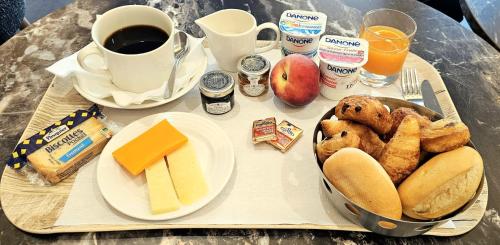 een dienblad met ontbijtproducten en koffie bij Domitys l'Esquisse in Valenciennes