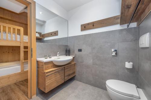 a bathroom with a toilet and a sink at Ravelli Sporting in Mezzana