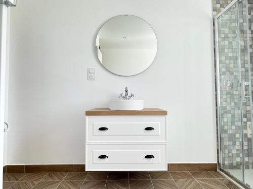 a bathroom with a sink and a mirror at La clairiere Maison spacieuse rénovée joliment décorée tout confort 12 p 2 sdb 2 wc grand jardin clos, belle terrasse aménagée, parking privatif, ping pong baby foot proche Omaha Beach et Bayeux in Crouay