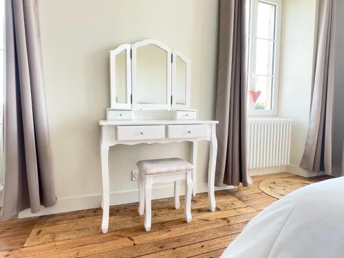 a white dressing table with a stool and a mirror at La clairiere Maison spacieuse rénovée joliment décorée tout confort 12 p 2 sdb 2 wc grand jardin clos, belle terrasse aménagée, parking privatif, ping pong baby foot proche Omaha Beach et Bayeux in Crouay
