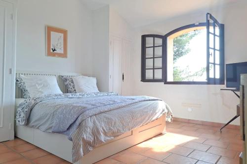 une chambre blanche avec un lit et une fenêtre dans l'établissement 4 BR Villa with Pool Sea View AC Parking - BENAKEY, au Cannet