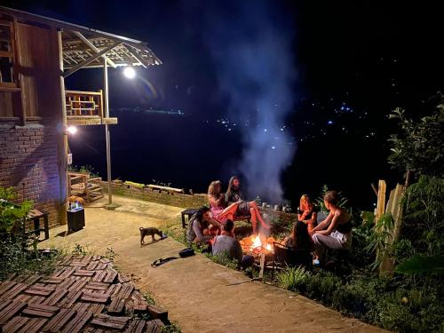 Eine Gruppe von Menschen, die nachts um ein Feuer herum sitzen in der Unterkunft Pham's House - Homestay & Cafe in Sa Pa