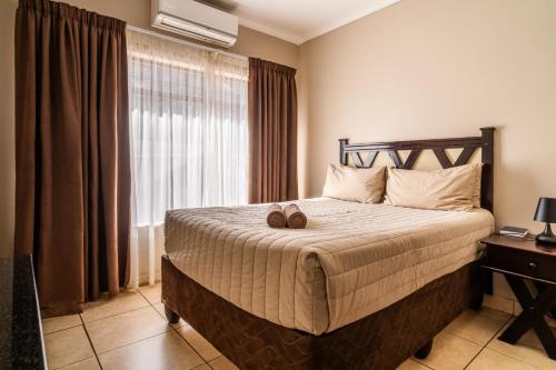 a bedroom with a bed with two shoes on it at ATKV Klein-Kariba in Bela-Bela