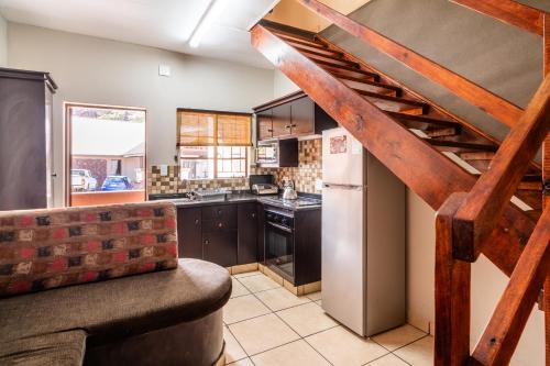 a kitchen with a staircase and a couch in a room at ATKV Klein-Kariba in Bela-Bela