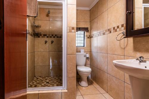 a bathroom with a shower and a toilet and a sink at ATKV Klein-Kariba in Bela-Bela