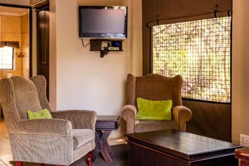 a waiting room with chairs and a flat screen tv at ATKV Klein-Kariba in Bela-Bela