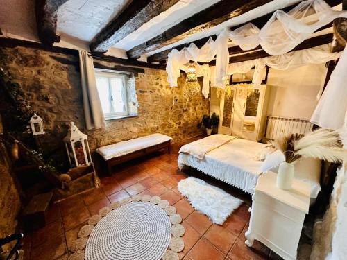 a bedroom with a bed in a room with a stone wall at Casona del Marquesado in Argüeso