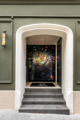 a doorway to a building with a painting on the wall at Hôtel Hiro Paris in Paris