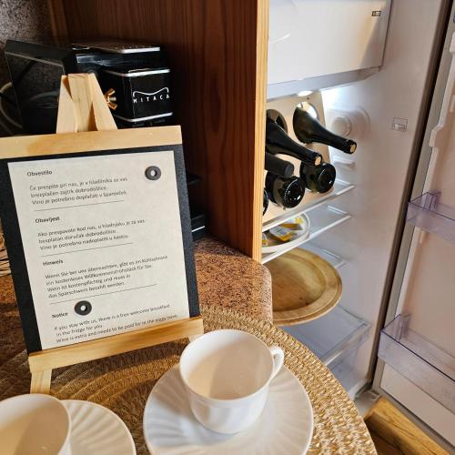 a cup of coffee sitting on a table next to a refrigerator at TRUTH WINES HOUSE in Veliki Vrh