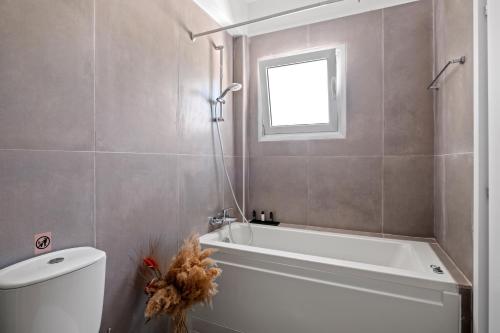 a bathroom with a tub and a toilet and a window at Villa Il Pino by Nomads - A Private Nature Retreat in Paphos