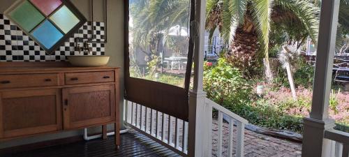 a porch with a dresser and a view of a garden at HouseMartin Lodge & Self Catering in De Rust