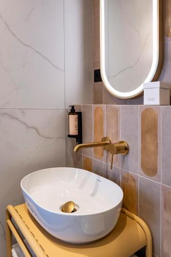 a bathroom with a white sink and a mirror at Hôtel Hiro Paris in Paris