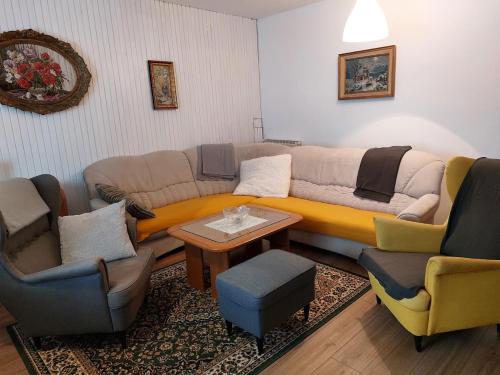 a living room with a couch and two chairs at Domačija pri Ivankovih in Osilnica