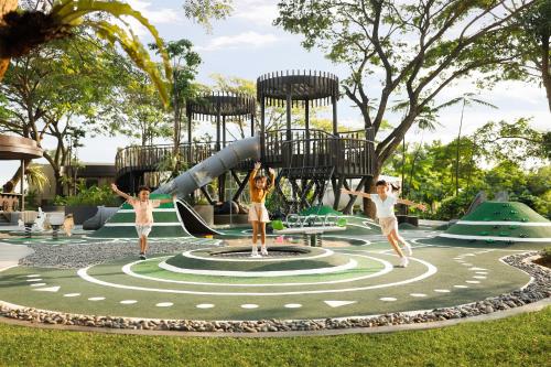 two girls playing on a playground in a park at Resinda Hotel Karawang in Karawang