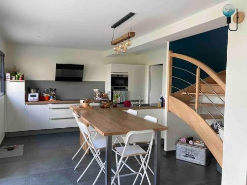 une cuisine avec une table en bois et un escalier dans l'établissement Très belle maison moderne ,hyper centre de Bayeux, à Bayeux