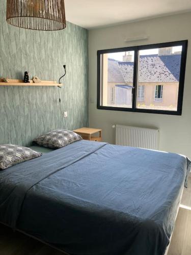 une chambre avec un lit bleu et une fenêtre dans l'établissement Très belle maison moderne ,hyper centre de Bayeux, à Bayeux
