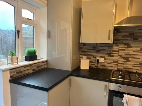 een keuken met witte kasten en een zwart aanrechtblad bij Budget stay in Thornaby on Tees