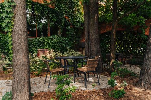 a table and chairs sitting under some trees at Hotel Sphinx in Żabia Wola