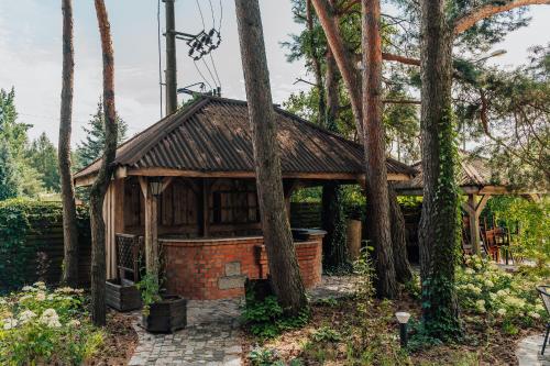 a pavilion in the woods with trees at Hotel Sphinx in Żabia Wola
