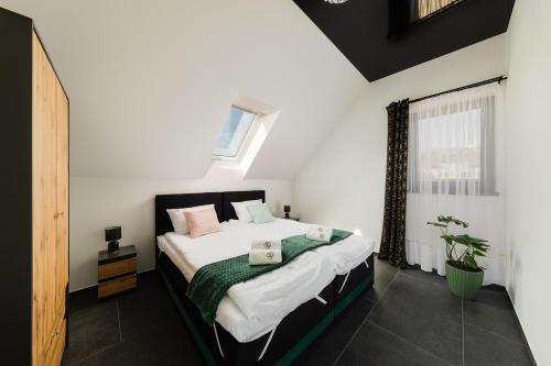 a bedroom with a bed with white sheets and a window at Villa Monster in Mrągowo