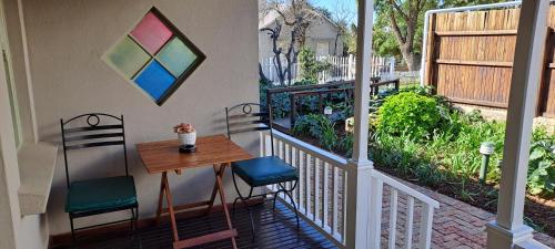 a balcony with a table and chairs on a porch at HouseMartin Lodge & Self Catering in De Rust
