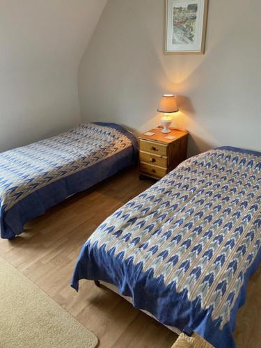 - une chambre avec 2 lits et une table de nuit avec une lampe dans l'établissement La Marée, à Portbail