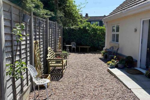 a backyard with chairs and a table and a fence at Helens Haven First floor apartment via stairs in Preston